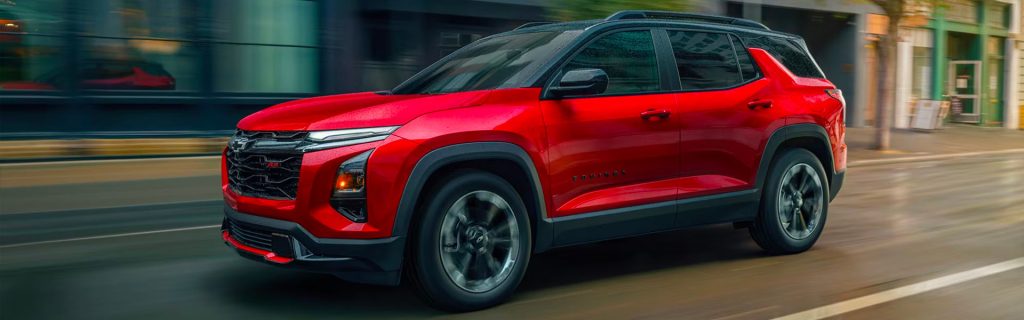 Red compact SUV driving through a city street in motion blur, likely a modern crossover vehicle.
