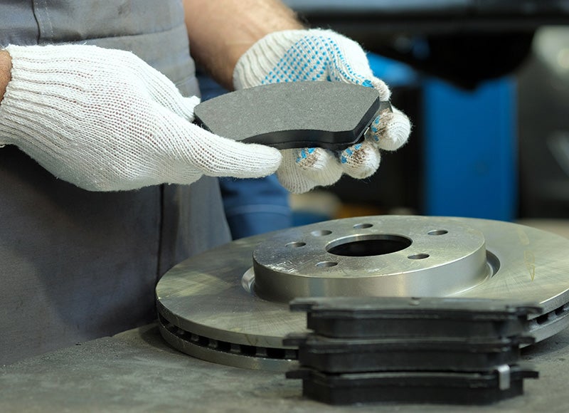 Brake pad and rotor replacement during automotive brake service inspection.